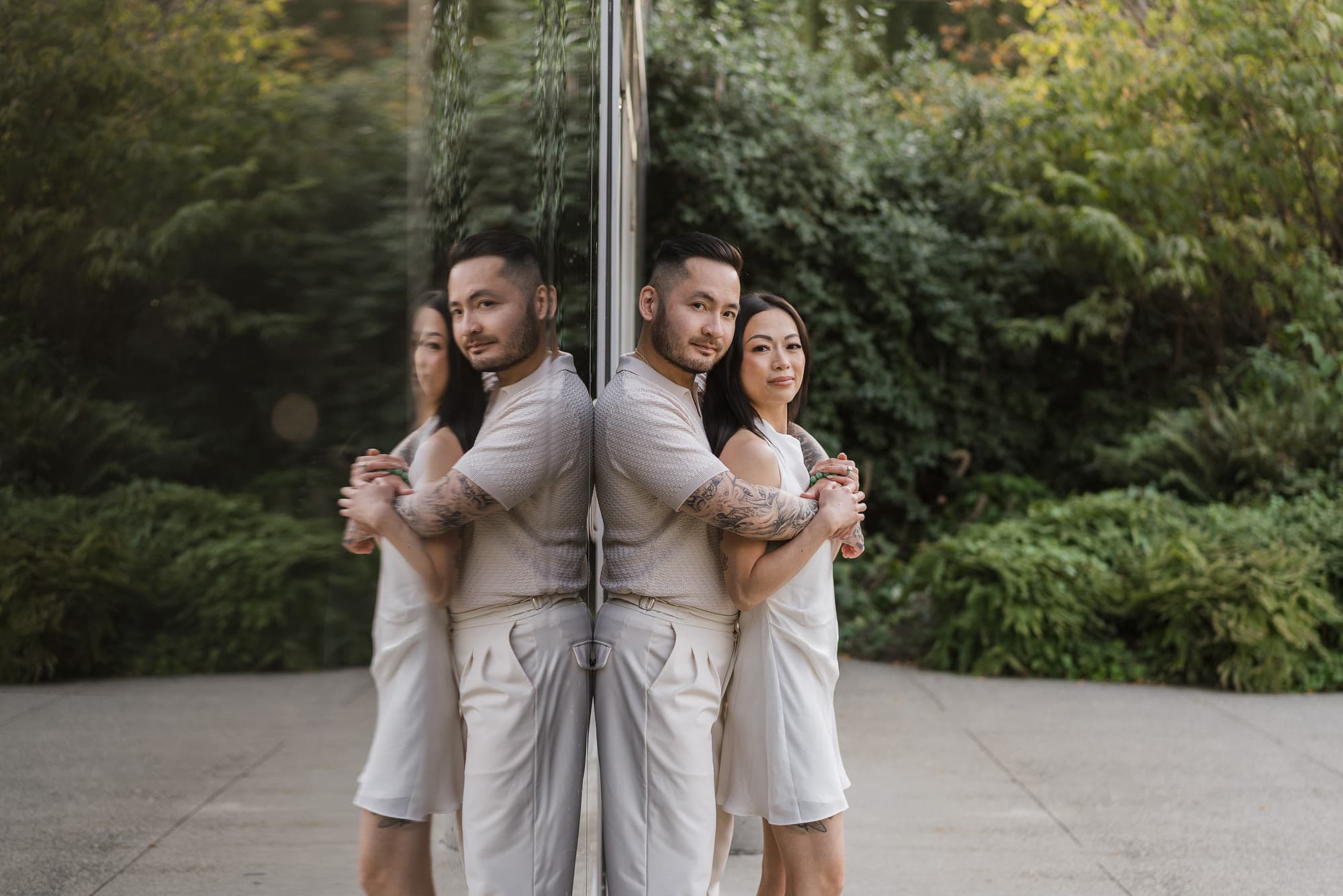 Alana and Colin reflected in a mirrored wall among the trees.